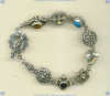 Sterling silver bracelet with mixed bezel set cabochon gemstones and ornate sterling silver beads and toggle. - Click for a larger picture