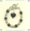 Sterling silver and black onyx gemstone bracelet with toggle clasp and onyx heart dangle. - Click for a larger picture