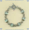 Bracelet with faceted blue quartz gemstones and hand made sterling silver beads, caps, and toggle. - Click for a larger picture